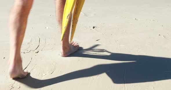 Senior man with flippers and diving mask standing on beach