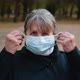 Portrait of a Senior Woman Putting on a Medical Mask and Looking Seriously at the Camera. - VideoHive Item for Sale