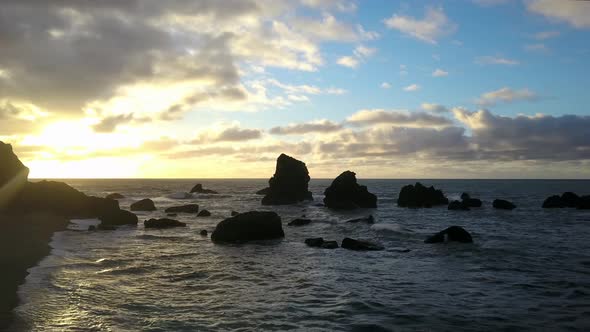 Beautiful ocean sunset breaking through clouds, drone 4k