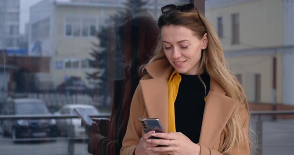 Woman with Smartphone Walking in the City