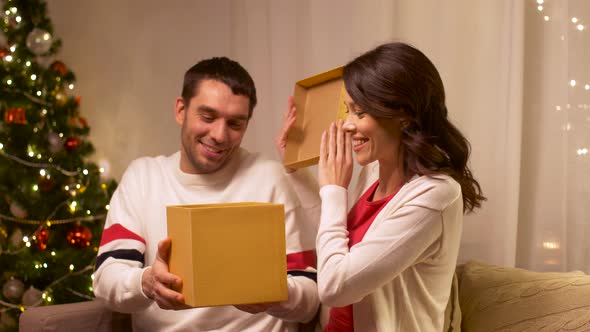 Happy Couple with Christmas Gift at Home 
