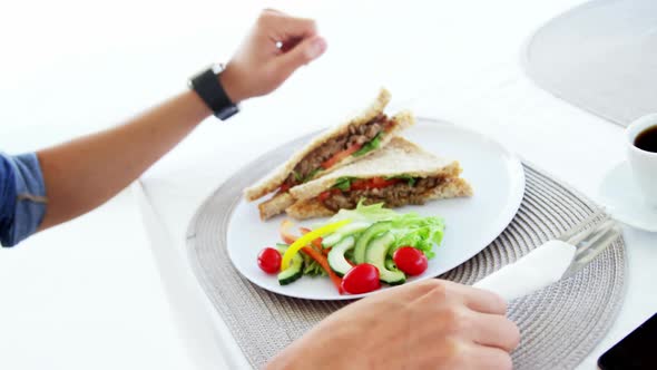 man eating lunch with coffee