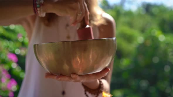 Superslowmotion Shot of a Woman Master of Asian Sacred Medicine Performs Tibetan Bowls Healing