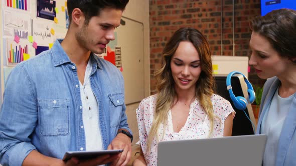 Group of business executives interacting over laptop