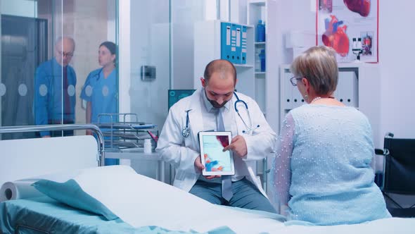 Cardiologyst Explainingar Rhythmias Disease on Digital Tablet