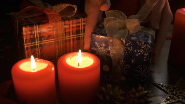 A Woman Puts a Gift on a Table Decorated with Christmas Decorations. Christmas and New Year Concept