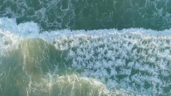 White foam and powerful ocean waves - top down aerial view