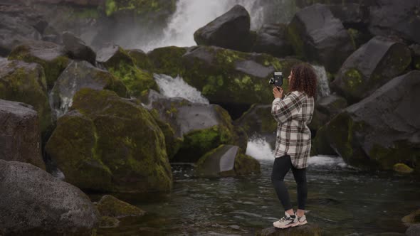 Woman Using Super 8 Camera To Film Oxararfoss Waterfall