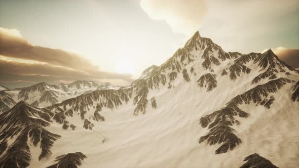 Panorama of High Snow Mountains at Sunset alt