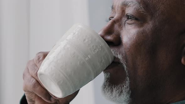 Side View African American Old 60s Lonely Business Man Drinking Coffee Tea From Cup Mug Looking Out