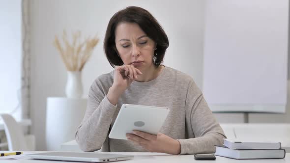 Pensive Old Senior Woman Thinking While Using Tablet