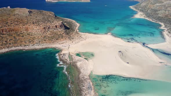 AERIAL: Beautiful white sand beach with turquoise water. Sunny summer day. Paradise. Crete, Greece