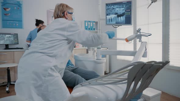 Orthodontist Pointing at Teeth Radiography on Monitor