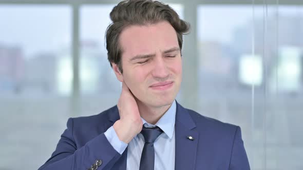 Portrait of Tired Young Businessman Having Neck Pain