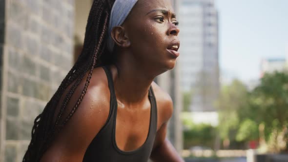 African american woman exercising outdoors taking rest breathing deeply in the city