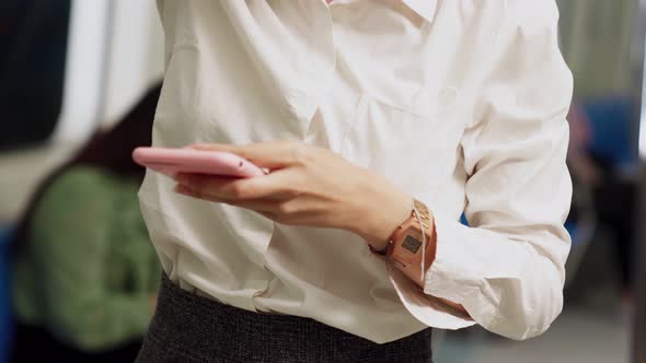 Young Woman Using Mobile Phone on Public Train