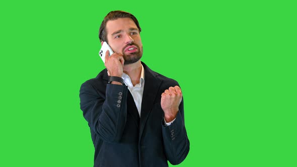 Young Businessman Having an Emotional Phone Conversation on a Green Screen Chroma Key