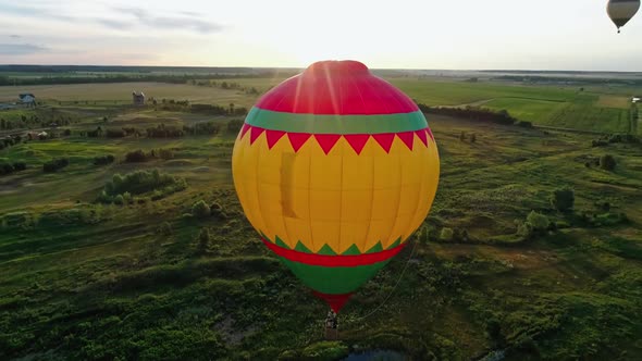 Colorful hot air balloon flying over fields