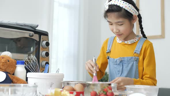 Pretty Asian girl baking homemade bakery cup cake.