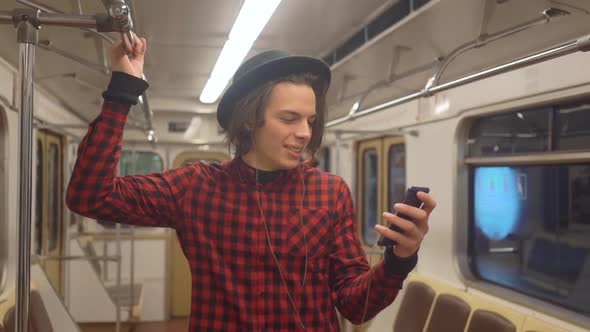 Young handsome stylish man wearing black hat with headphones listening to music