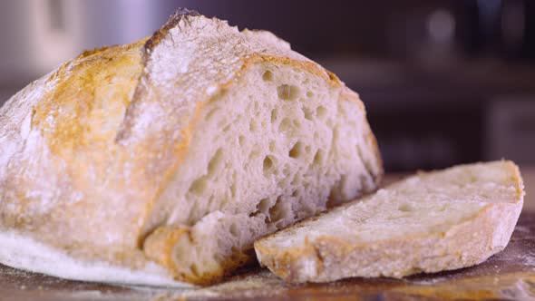 Freshly Baked Loaf Of Sourdough Bread With A Slice - close up, pan shot