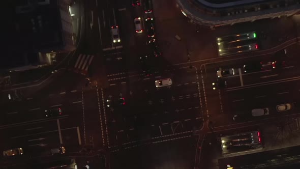 AERIAL: Beautiful Overhead Shot of Busy Intersection at Night with Car Traffic and City Lights 