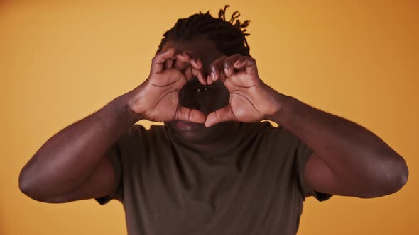 African Man Making Heart Shape with His Hands, Close Up.