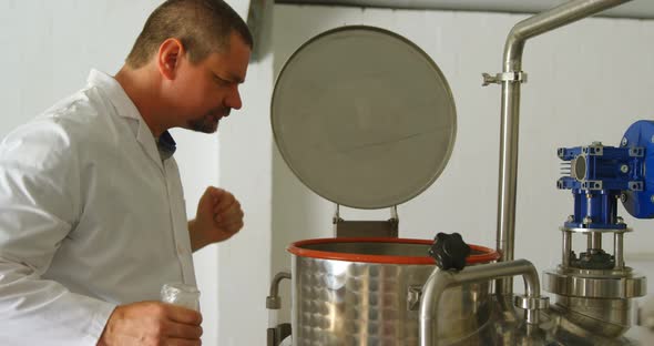Male worker checking distillation tank in factory 4k