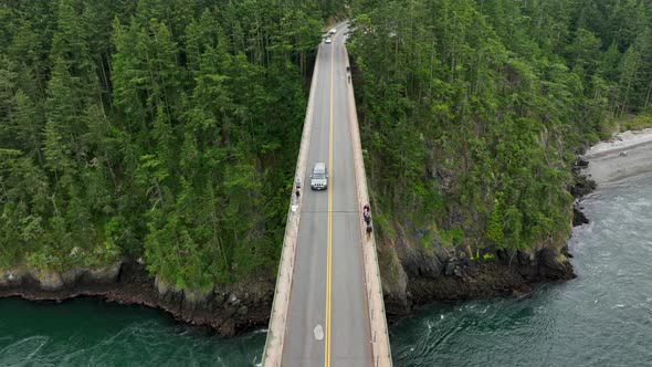 Overhead aerial shot of a car driving over Deception Pass bridge in Washington State.