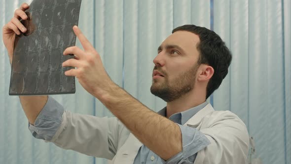 Male Doctor Looking with Humorous Shock at x Ray