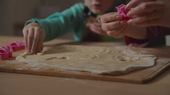 Hands Cutting Forms with Cookie Cutter From Dough