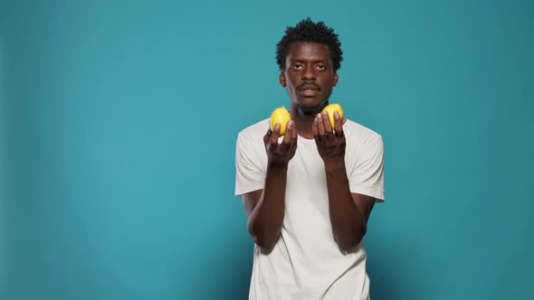 Cheerful Person Holding Lemons for Healthy Vegetarian Diet