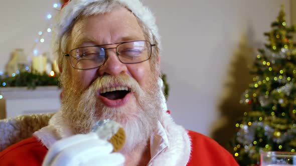 Santa claus relaxing on chair and having sweet food