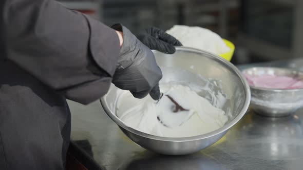 Camera Moves Up From Female Hands Mixing Topping Ingredients in Bowl to Face of Concentrated Young