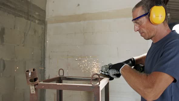 Man using a metal grinder on a metal object with sparks flying in slow motion