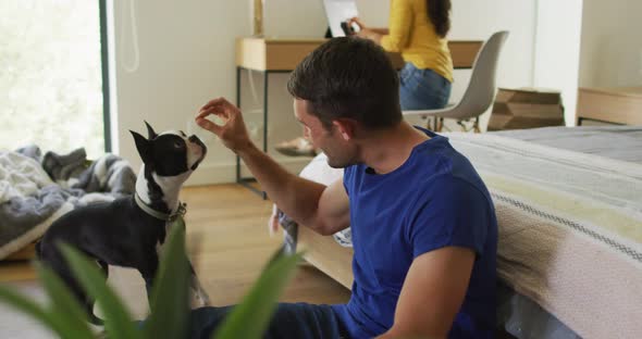 Caucasian man is playing with his dog at home