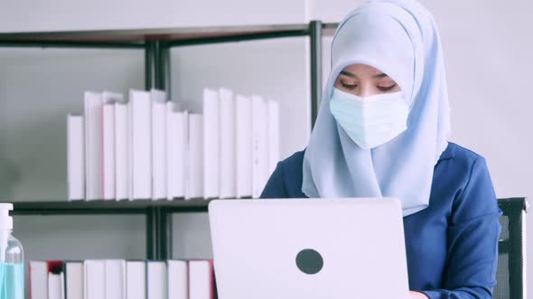 Muslim businesswoman wearing protective masks while working in office.