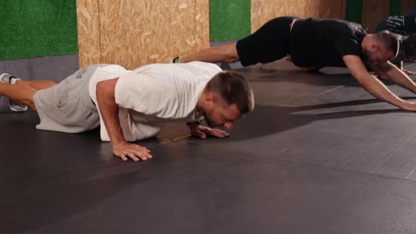 Fulllength Shot Groups Athletes Engaged in Sport Looking Away Doing Pushups