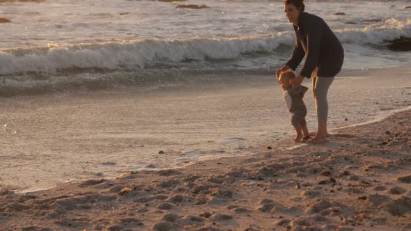 Mother and baby boy playing in the beach