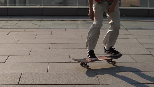 Feet of Skateboarder Doing Ollie Trick Outside