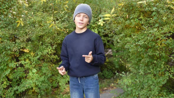 Boy Speaks in Front of Video Camera for His Blog Channel in Autumn Outdoors