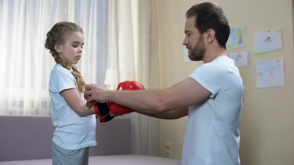 Caring Father Helping Daughter Put on Boxing Gloves, Sport Childhood, Training