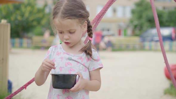 Little Girl Eat Ice Cream Spoon Outdoor Playground Plastic Plate Summer Day Slow Motion
