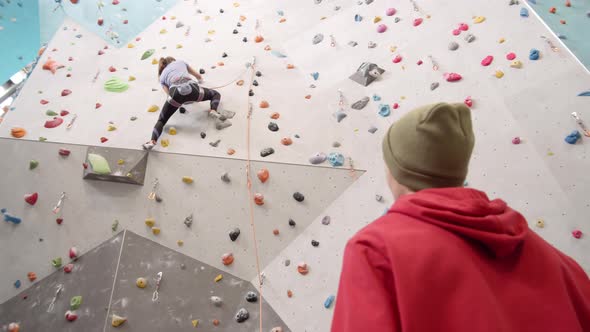 Instructor Watching Sporty Woman Climbing