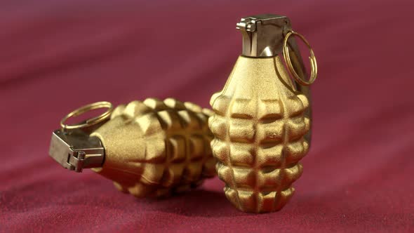 MK2 hand grenades. Two golden pineapple grenades on the red velvet cloth.