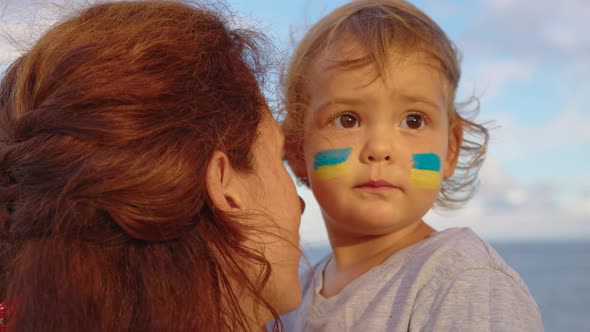 Close Up Portrait Little Baby and Mom with Flag of Ukraine on Face