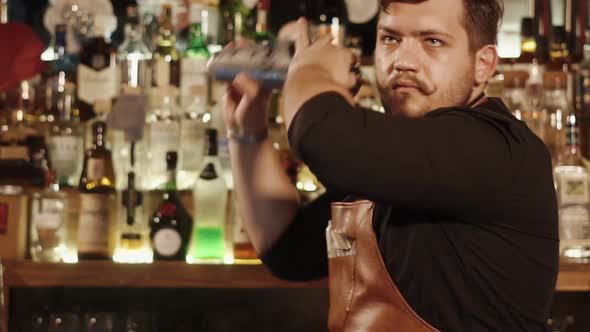 Serious Barman with Funny Moustache Is Shaking Metal Bowls with Cocktail