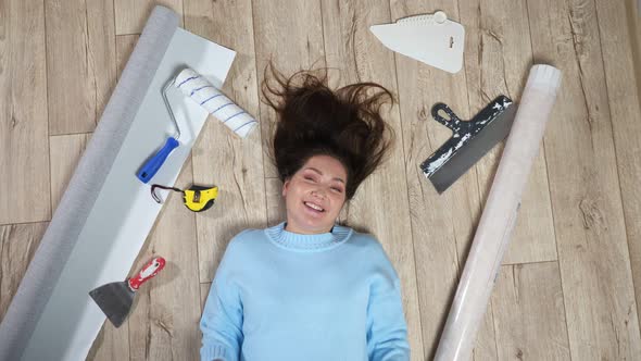 Woman Lies on Floor Among Scattered Building Materials