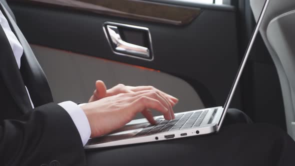 Close Up of Male in Formal Wear with Laptop in Luxurious Car