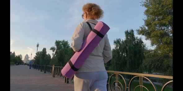 Senior Woman with Fitness Mat Walking